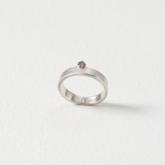 Gold & Stone Ring - Representing new beginnings and the promise of a new dawn, this stacking ring is handcrafted in matte sterling silver from silver wire, and displays a salt and pepper diamond set in 18k gold. Handmade in Seattle, WA, each ring will vary slightly. Minimalist Sterling Silver Diamond Ring With Single Cut Diamonds, Minimalist Silver Stackable Rings With Tension Setting, Minimalist Silver Rings With Tension Setting, Minimalist Silver Rings With Single Cut Diamonds, Modern Sterling Silver Ring With Single Diamond, Minimalist White Topaz Diamond Ring In White Gold, Minimalist White Gold Diamond Ring With White Topaz, Minimalist Sterling Silver Diamond Ring With Tension Setting, Minimalist Silver Diamond Ring With Single Cut Diamonds