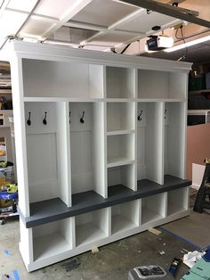 a garage storage area with white cabinets and black benches