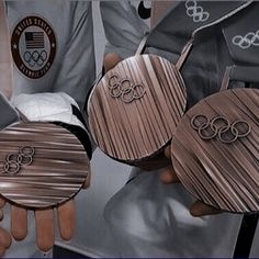 the olympic medals are being held by two hands