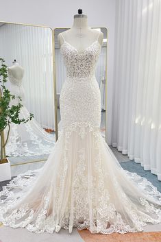 a wedding dress on display in front of a mirror