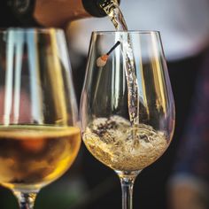 wine being poured into a glass with ice