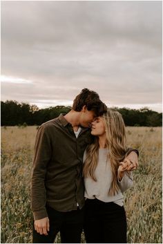 a man and woman kissing in a field