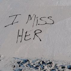 the word i miss her is written in black ink on a white surface with blue spots