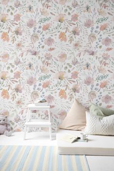 a white bed sitting next to a wall covered in flowers