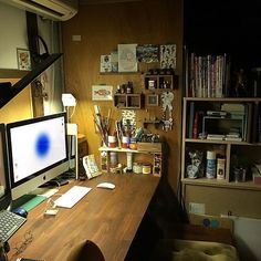 a desk with a computer monitor, keyboard and mouse on it in front of a bookshelf