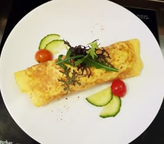 an omelet with cucumbers and tomatoes on a white plate