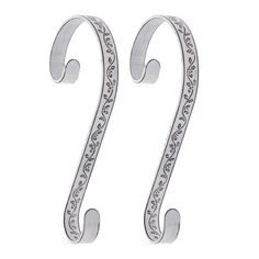 pair of silver earrings with scroll design on the front and back ends, hanging from a hook