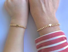 🔹This is a beautiful set of matching mother/daughter beaded bracelets. These make a perfect gift for a mama and daughter duo, or any ladies who want to show their special connection.  Matching with your little is always fun and these dainty bracelets make dressing up even more special! 🔹The bracelets are made with 18k gold plated, 24k gold filled, rose gold or silver plated 4mm beads and a matching heart strung together with a strong double strung elastic cord. Gold filled beads have a thicker layer of gold and will last for much longer. 🔹Each stackable item is packed in a beautiful organza bag and a handwritten message can also be included. It makes the perfect gift for Christmas, a baby shower, new mom, Mother's Day, bridal shower, birthday and Valentine's Day.  🔹Length: Mama bracele Gold Beaded Bracelets For Mother's Day Gift, Mother's Day Friendship Bracelets With Round Beads, Mother's Day Gift Friendship Bracelets With Round Beads, Round Beads Bracelet As Gift For Mom, Personalized Bracelets As Mother's Day Gifts, Gold Bracelets With Round Beads For Mom, Gold Round Beads Bracelet As Gift For Mom, Gold Bracelet With Round Beads As Gift For Mom, Heart Beaded Bracelets As Mother's Day Gift