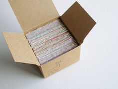 a cardboard box filled with lots of different colored papers