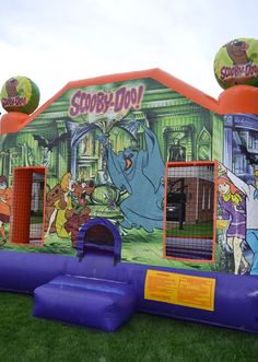 an inflatable bouncy house with cartoon characters painted on the front and sides