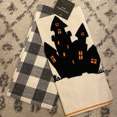 two napkins with black and white designs on them, one has a house in the middle