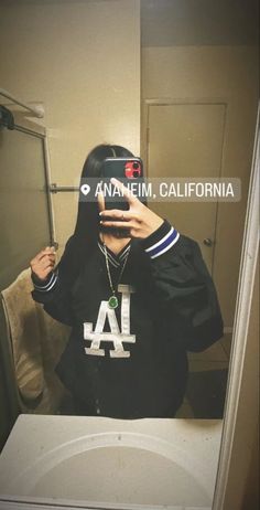 a person taking a selfie in front of a mirror with the los angeles dodgers logo on it