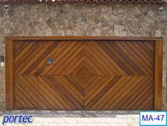 a large wooden garage door in front of a stone wall