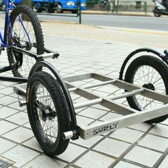 two bikes are parked on the side of the road with one wheel attached to it