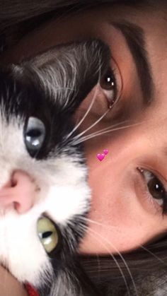 a close up of a person holding a cat with their face next to the camera