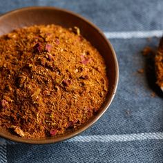 a wooden bowl filled with spices on top of a table