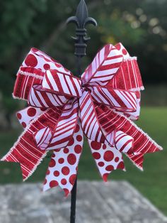 a red and white bow sitting on top of a pole