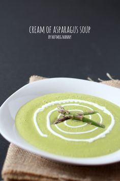 a white bowl filled with green soup on top of a table