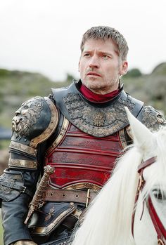 a man in armor riding on the back of a white horse with his eyes closed