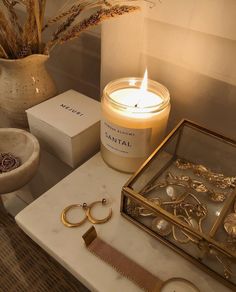 a candle and some jewelry on a table