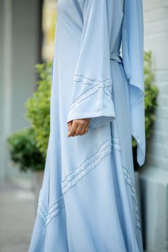 Stride with elegance and sophistication in our Hanan Abaya. Made with buttery-soft Nida fabric, Hanan is designed with tiny crystals for the perfect hint of glam and shimmer. The coveted A-line cut gives you a beautiful drape and that amazing Muslimah flow. Feel and look like a queen in this timeless, classy abaya. Made with ultra-soft luxurious silk Nida Open abaya with hidden buttons Shayla (hijab) included Sleeveless dress not included Model is 5'4 and is wearing size 56 Made in Dubai Shayla Hijab, Classy Abaya, Dresses Hijab, Open Abaya, Beautiful Drapes, Classic Black, Dubai, Sleeveless Dress, Short Sleeve Dresses