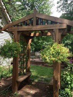 a wooden gazebo sitting in the middle of a garden