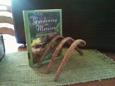 a book sitting on top of a wooden table next to a green cloth covered chair