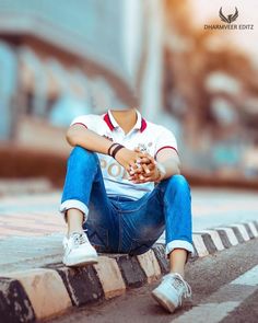 a person sitting on the curb with their hands together