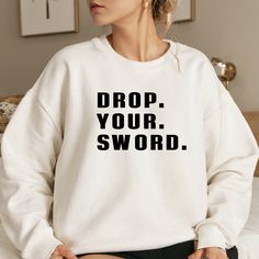 Calling all fans of Westley, Buttercup, and The Princess Bride! This long sleeve cozy sweatshirt is the perfect gift for the movie lover in your life. "Drop. Your. Sword." About - Classic fit unisex crewneck sweatshirt - Comfortable and cozy medium-heavy blend fabric with ribbed knit collar - Tear-away label - Fabric blends: 50% cotton and 50% polyester - Made with 100% ethically grown US cotton How to Order 1. Select your sweatshirt size from the dropdown menu. (Please review size chart in phot Fandom Long Sleeve Tops With Letter Print, Long Sleeve Fandom Tops With Letter Print, The Princess Bride, Bride Sweatshirt, Movie Quote, Quote Shirt, Princess Bride, Movie Lover, Funny Sweatshirts