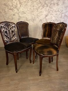 three chairs with animal print upholstered on the back and sides, in front of a wall