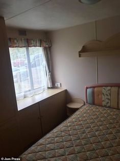 a bed sitting next to a window in a bedroom