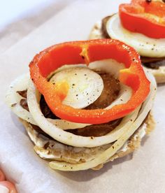 an egg and onion sandwich on toasted bread with red peppers in the middle, topped with mayonnaise