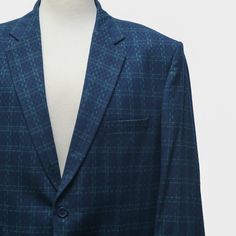 This Chiragh Apparel blazer is an elegant upgrade on dapper tailoring and features rich shades in a sumptuous fabric for elegant opulence. Fashioned from premium quality wool, this geometric check blazer features full lining in Japanese silk, a notch lapel, two-button closure and single-vented back. A left chest pocket and three flap pockets appoint the front while the inside has two (2) pockets on the left and one (1) pocket on the right. A flash of contrast piping is added to the jacket lining Formal Blue Blazer With Suit Collar, Blue Notch Lapel Blazer In Suiting Fabric, Blue Notch Lapel Blazer, Tailored Notch Lapel Tweed Jacket For Wedding, Tailored Tweed Jacket With Notch Lapel For Wedding, Elegant Notch Lapel Tweed Jacket For Wedding, Formal Tailored Blue Blazer, Tailored Blue Blazer For Formal Occasions, Blue Tailored Blazer For Formal Occasions