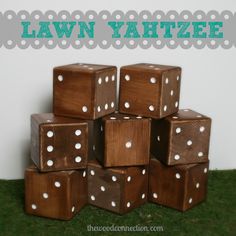 several wooden dices stacked on top of each other in front of the words lawn yahtze