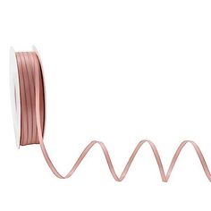 a spool of pink satin ribbon on a white background with the cord in the shape of a spiral