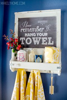 a bathroom shelf with towels, soaps and other items on it next to a blue wall