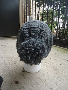 a knitted hat sitting on top of a white table next to a black door