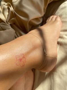 a person with a flower tattoo on their left arm and foot, laying in bed