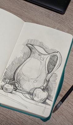 an open notebook with a drawing of a pitcher and apples on the table next to it