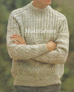 a man with his arms crossed wearing a sweater