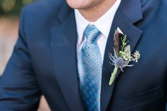 a man in a suit and tie with a boutonniere on his lapel