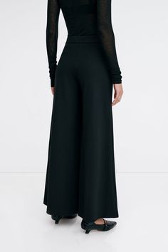 Claremont does all the legwork to keep your Monday-Sunday wardrobe polished. These relaxed wide-leg pants are fashioned from structured European ponte with a fly-front zipper and a wide waistband that rests comfortably at the mid-waist. Finished with functional pockets and a tuxedo panel to accentuate her clean lines. | Astrid, in black and in mist, is 5'9" (175 cm) tall, wearing size XS. Sejal, in black, is 5'8" (173 cm) tall, wearing size M. Approximately 39.5" (10.5 cm) from below the belt. Inseam is approximately 30" (76 cm). European Ponte, also known as Punto di Roma (60% Viscose, 30% Polyamide, 10% Lycra).Machine wash on delicate cycle, or hand wash in cold water. Tumble dry on low heat, or for best results, lay flat to dry. Designed in NYC. Handcrafted in Europe. | Marcella Claremo Sleek Wide-leg Pants For Fall, Sleek Wide Leg Pants For Spring Evenings, Sleek Wide Leg Spring Pants, Sleek Wide Leg Pants For Evening In Spring, Sleek Wide Leg Pants For Spring, Sleek Wide Leg Pants For Evening And Spring, Sleek Evening Wide Leg Pants For Spring, Versatile Straight Leg Evening Bottoms, Full Length Culottes For Work