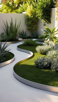 an outdoor garden with grass and plants in the center, surrounded by white concrete walls