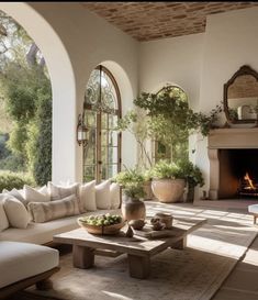 a living room filled with furniture and a fire place in the middle of an open floor plan