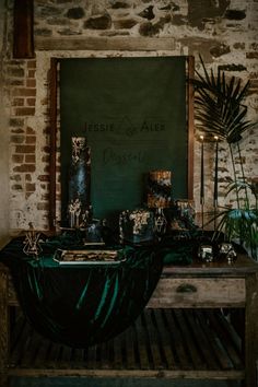 the table is set up with candles and other items on it, along with a chalkboard