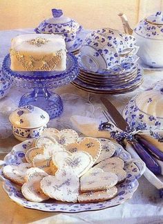 a table topped with blue and white plates covered in cookies