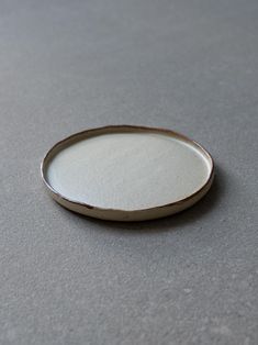 a small white plate sitting on top of a gray countertop next to a knife