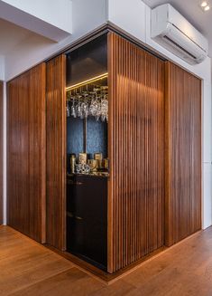 a room that has some wine glasses on the shelf in front of it and an air conditioner hanging from the ceiling