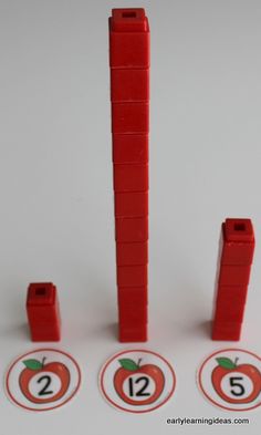 four red lego blocks with numbers on them and an apple in the middle one has two green leaves