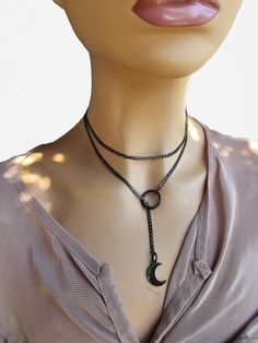 This is a bold and edgy blackened steel Gothic moon minimalist Lariat Necklace choker with a great Pagan witch aesthetic. This is a minimalistic, small curb chain with .5 inch crescent moon charm. The minimalist design gives it a trendy and stylish feel, while the black steel gives it a touch of gothic Punk edge. Please understand that this necklace is not designed for play, it is ornamental. ALSO IN STEEL AND GOLD! STEEL: https://shieldmaidensjewelry.etsy.com/listing/1804896523 GOLD: https://sh Gunmetal Minimalist Adjustable Jewelry, Trendy Black Lariat Jewelry, Gunmetal Adjustable Minimalist Jewelry, Handmade Black Lariat Necklace As Gift, Minimalist Gunmetal Metal Jewelry, Handmade Black Lariat Necklace For Gift, Pagan Witch Aesthetic, Edgy Gunmetal Jewelry With Adjustable Fit, Modern Black Lariat Jewelry